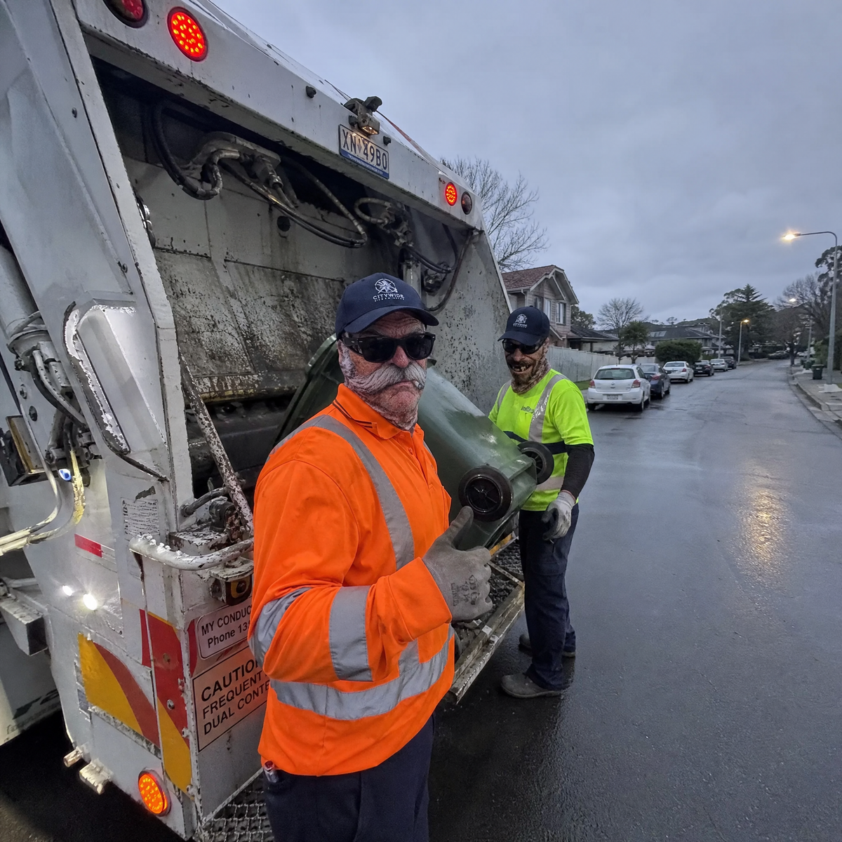 Garbage crew wearing the masks behind the truck